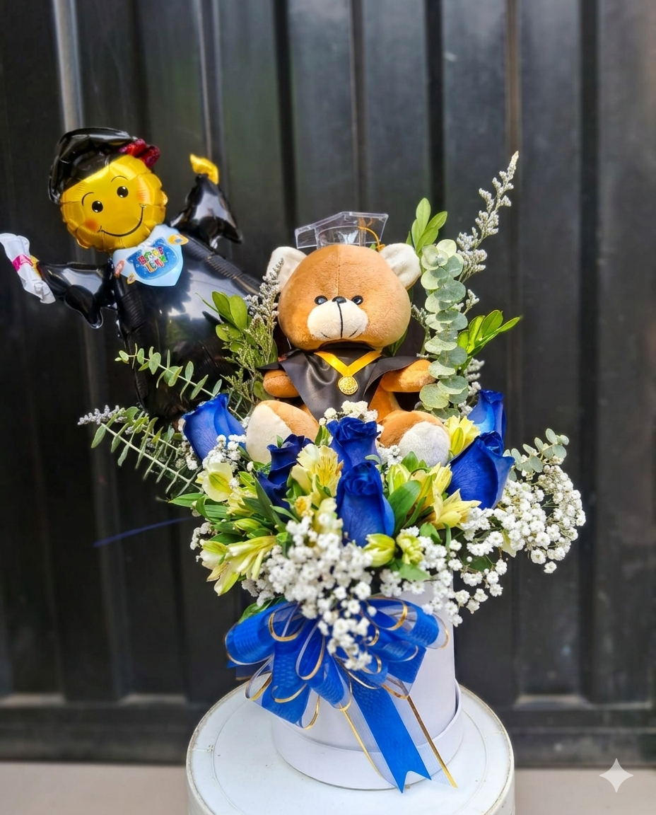 Exclusivo arreglo de graduación con rosas de un impactante azul profundo, un tierno oso graduado y un globo temático. 
